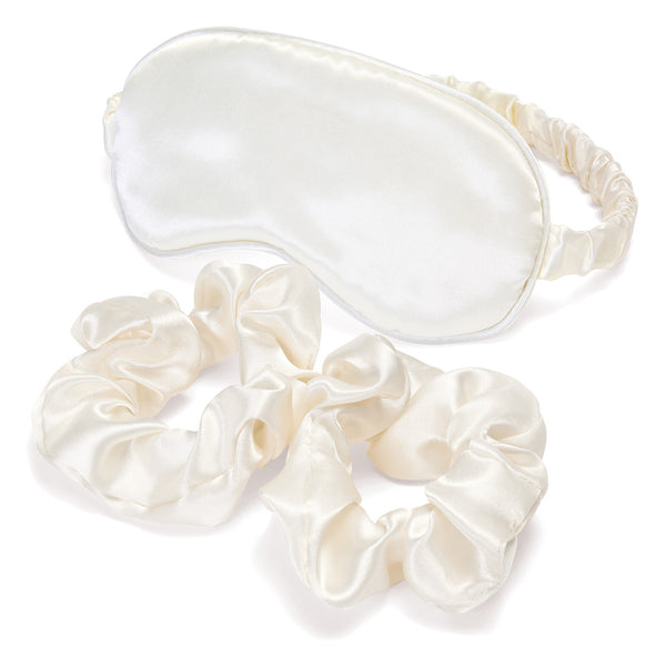 Set of cream-colored satin eye mask and scrunchies on a white background